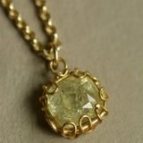 Tanzanian sapphire charm pendant in mellow pale green and yellow hues set in an organic 22k and 18k gold handcrafted setting.