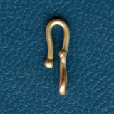A gold charm connector hook sits on a teal blue textured backdrop.