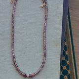 Malaya garnet beaded necklace on book stack.