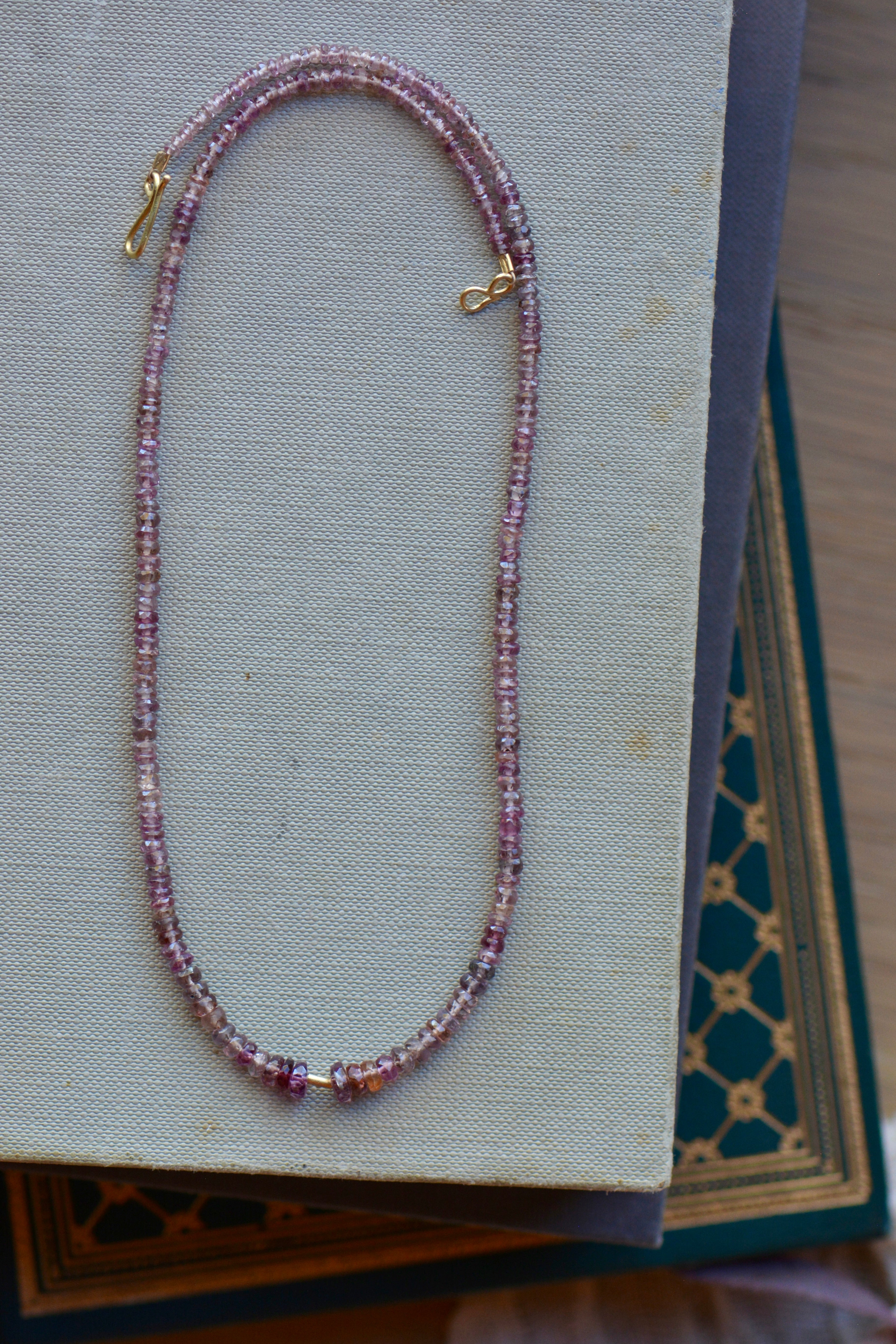 Malaya garnet beaded necklace on book stack.