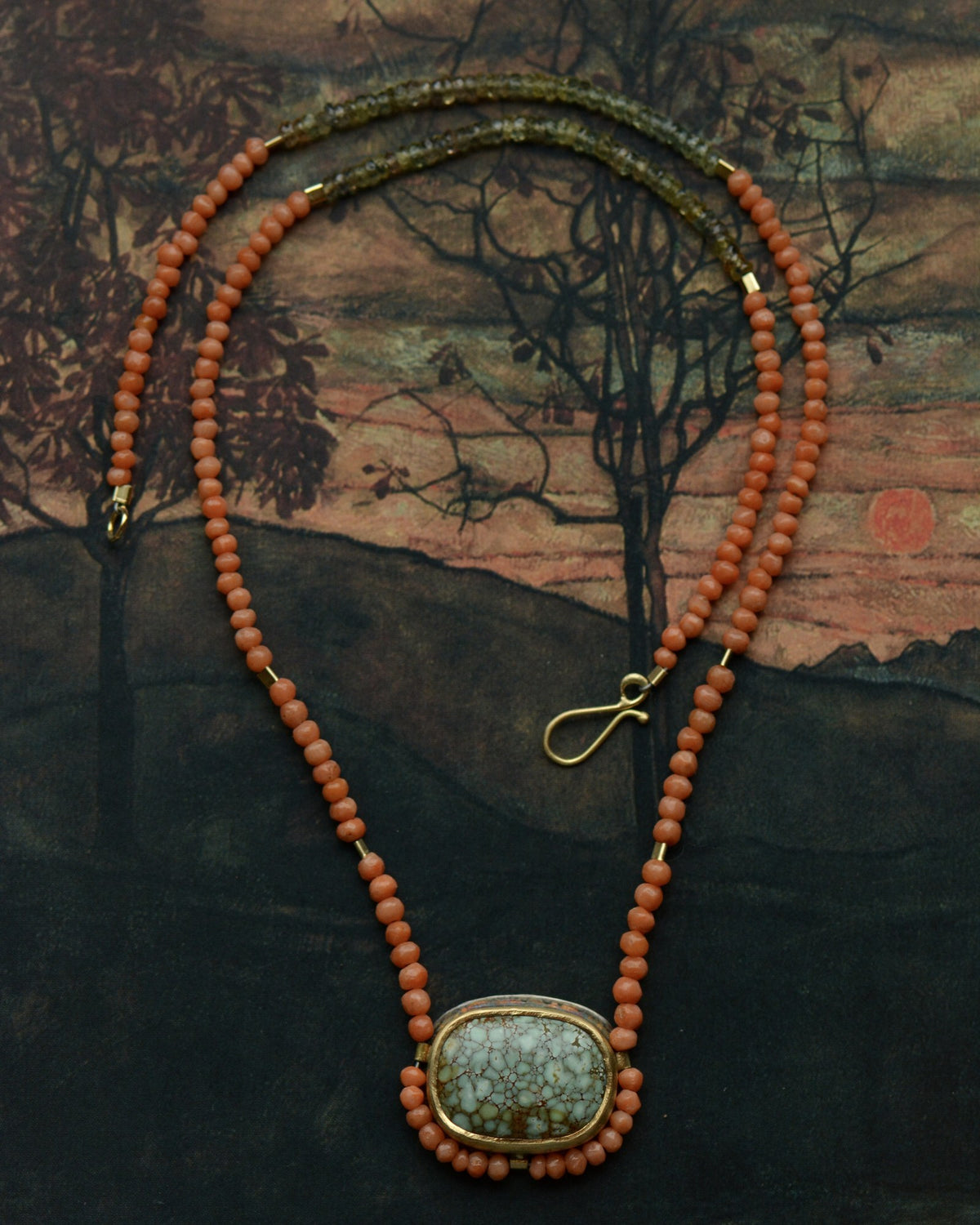 Coral bead and gem necklace by Lori Francescutti resting on one of her own paintings