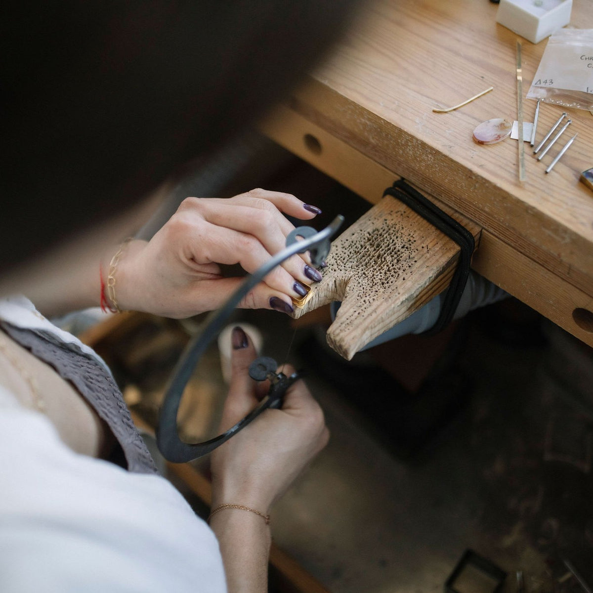 Lori Francescutti sawing metal at her bench